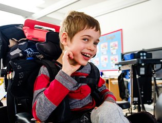 Smiling young boy in a wheelchair