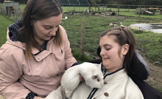 White guinea pig on a young person's chest