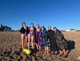 6 women on the beach in swimming suits