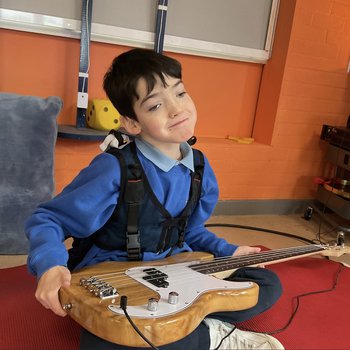 Boy holding an electric guitar on his lap