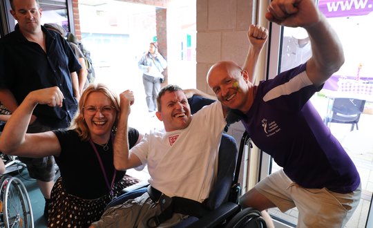 three people smiling with their muscles out