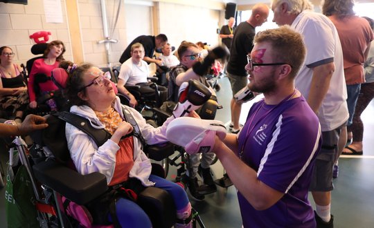 young girl boxing with man in purple top