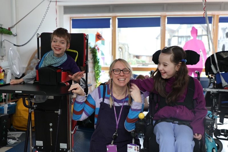 Teacher and two pupils smiling