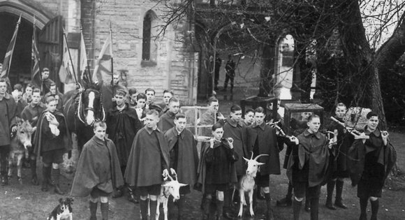 A black and white photo of young people with animals