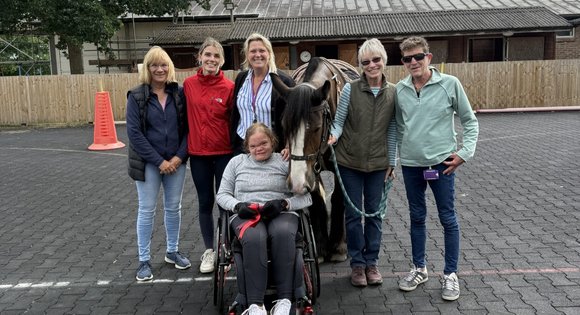 Group of people stood in riding arena