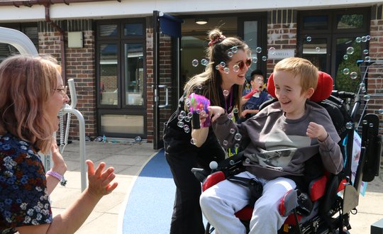young person smiling shooting bubble gun