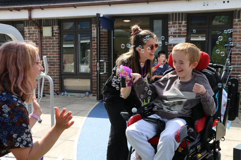 young person smiling shooting bubble gun