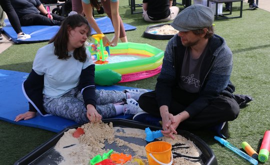 Young person playing with sand pit