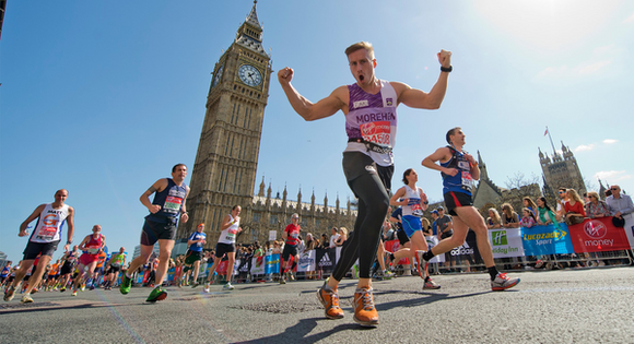 A male runner celebrating in front of Big Ben