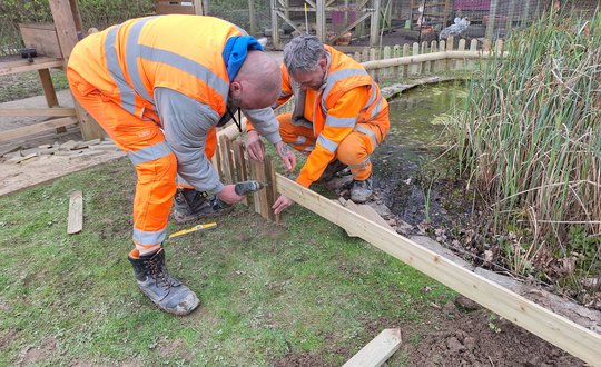 Men fencing the pond